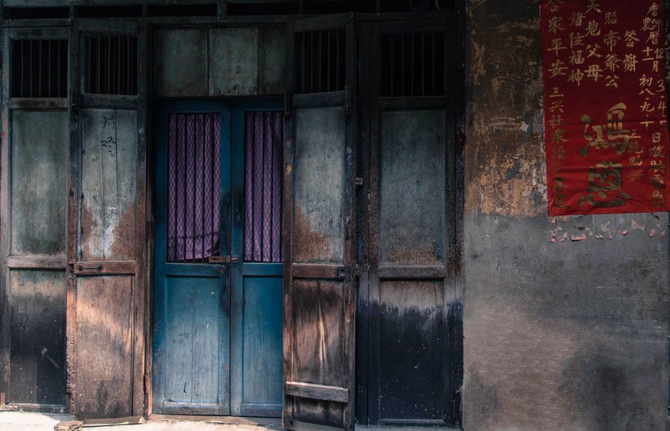 Rustic wooden doors with a traditional red Chinese poster, offering a vintage aesthetic.